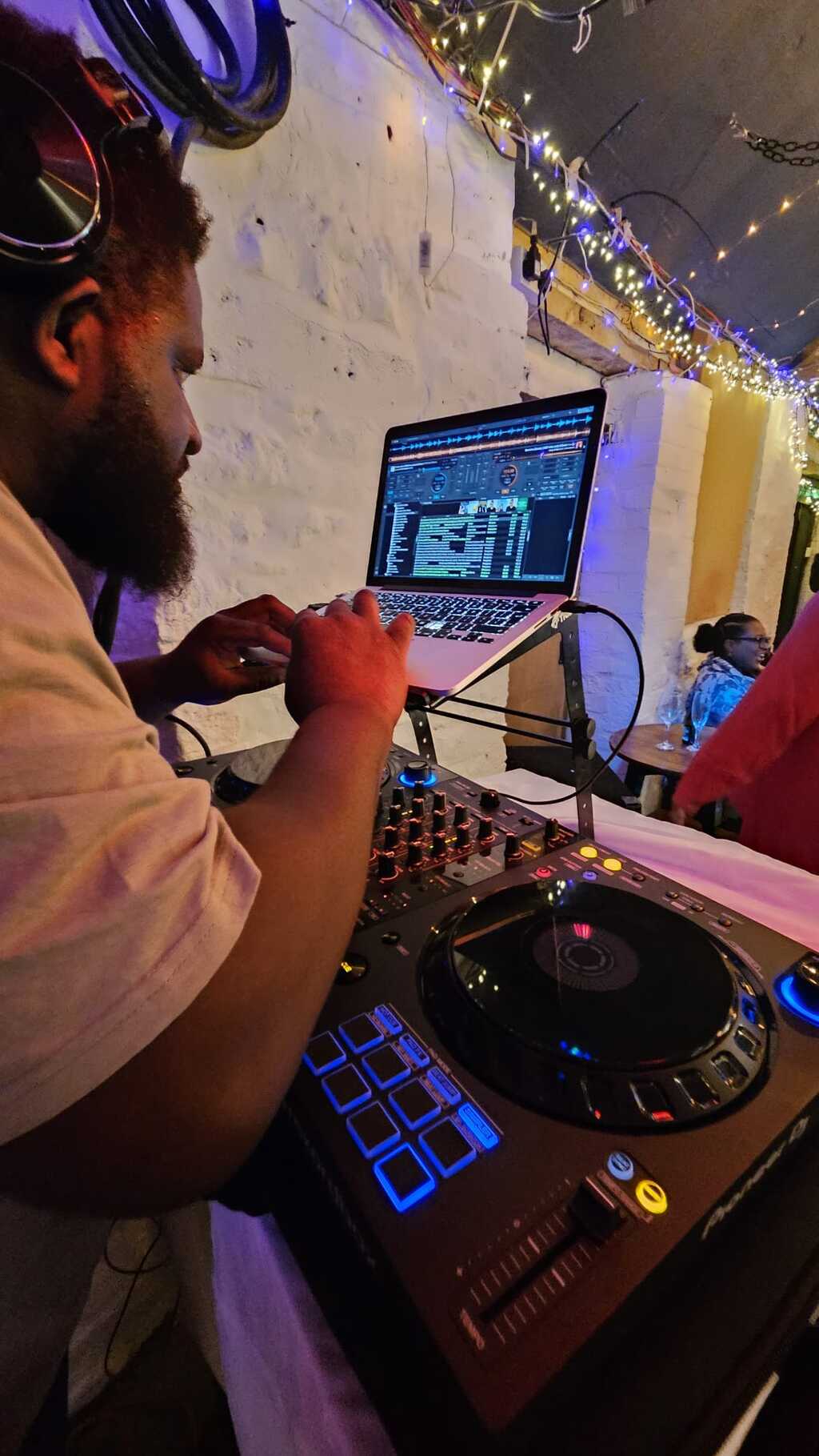 DJ S.M.A working from the DJ booth with decks and laptop